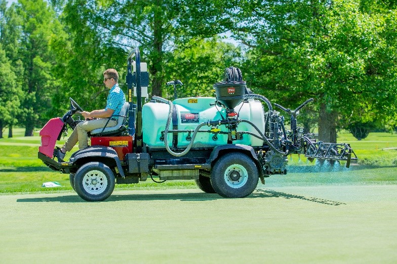 spray tank truck spraying colorants on a course